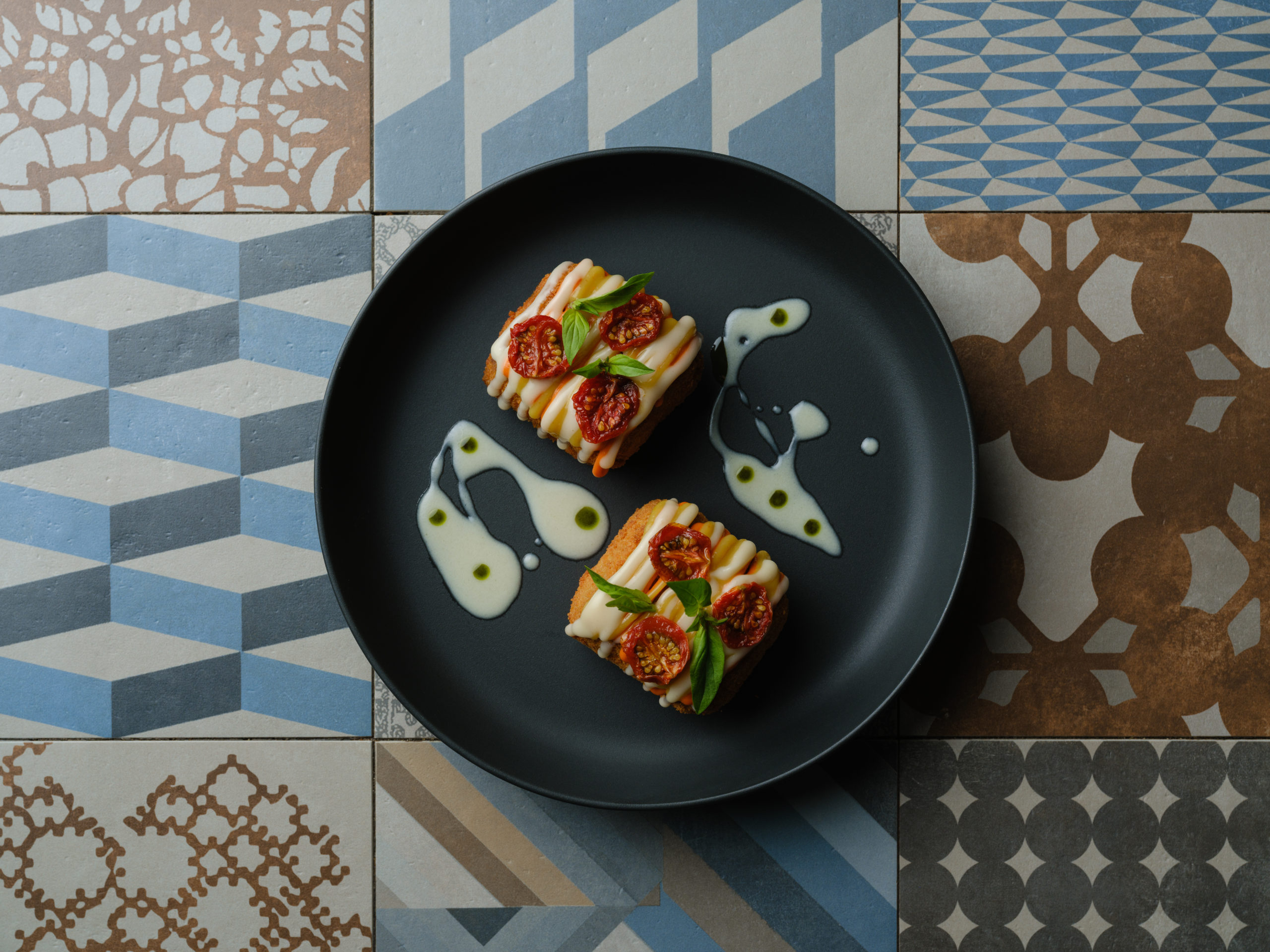 Parmigiana d’aubergines revisitée, tomates jaunes et rouges confites, basilic frais et parmesan – création méditerranéenne du restaurant gastronomique La Dispensa à Neuchâtel.